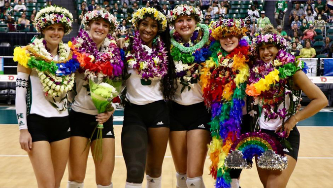 six people in uniforms with flower leis